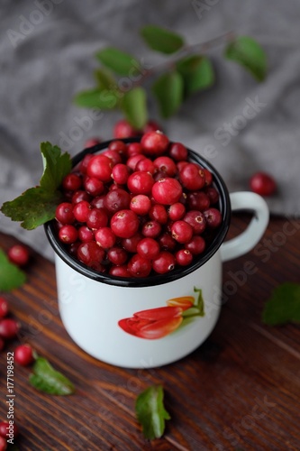 Fresh red cranberries with leaves on the table 