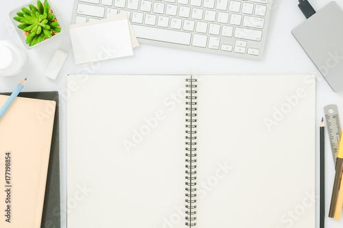 Blank notebook page on modern white office desk table with supplies for mockup. Top view, flat lay