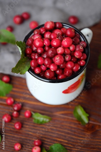 Fresh red cranberries with leaves on the table 