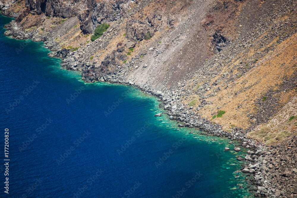 Volcanic mountains and turquoise water in Santorini island.