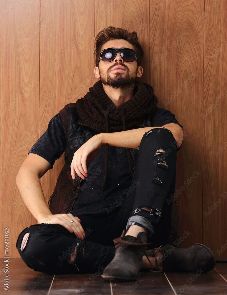 casual young man with beard sitting on the floor casual young man with beard sitting on the floor