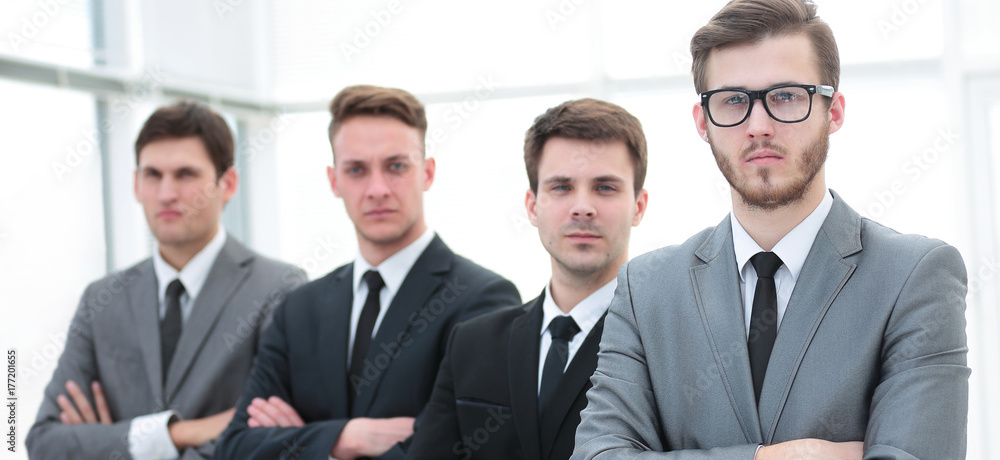 Confident business team standing in front of a bright window Confident business team standing in front of a bright window