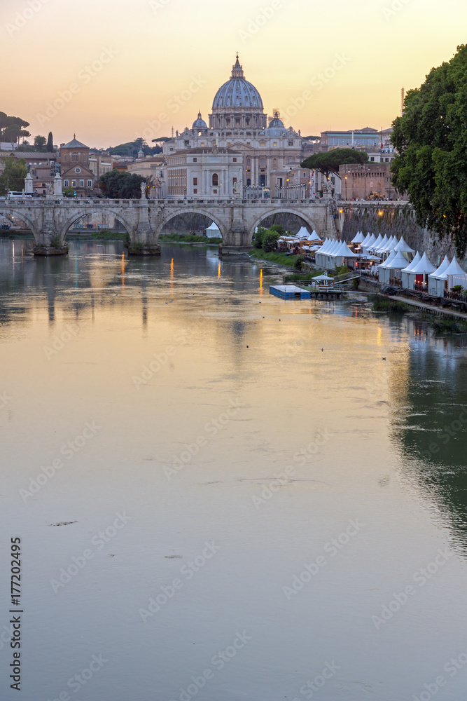 ROME, ITALY - JUNE 22, 2017: Amazing Sunset view of Tiber River, St. Angelo Bridge and St. Peter's Basilica in Rome, Italy