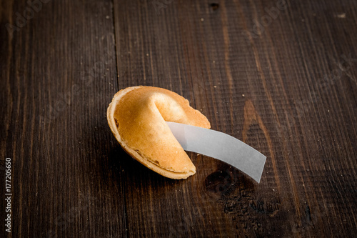 Chinese fortune cookie with prediction on wooden background space for text