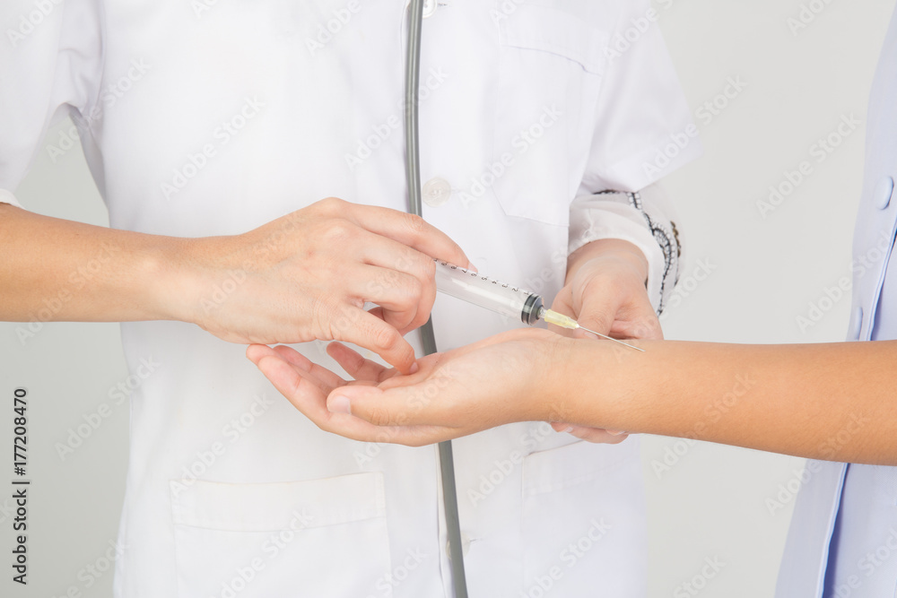 Doctor giving an injection to a patient on white background. Doctor giving an injection to a patient on white background.