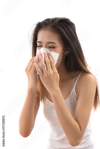 Flu cold or allergy symptom. Sick young woman girl sneezing in tissue isolated on white background. Asian woman use of the tissue. Health care concept. Studio shot.