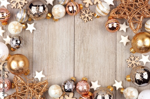 Christmas frame with white and gold ornaments on a rustic wood background