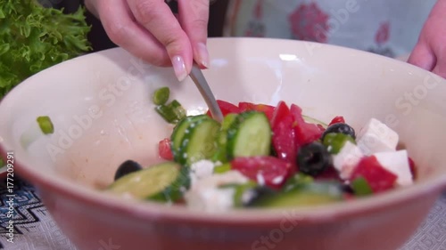 Stirring the Greek salad with butter and cheese