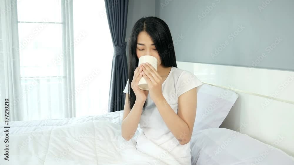 4k of Asian woman drinking water at her bedroom. 4k of Asian woman drinking water at her bedroom.