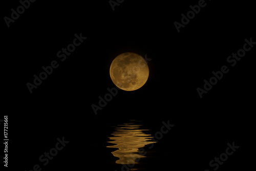 Full moon night with water reflection.