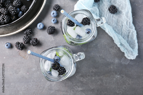 Refreshing water with blackberries and blueberries in mason jars on table