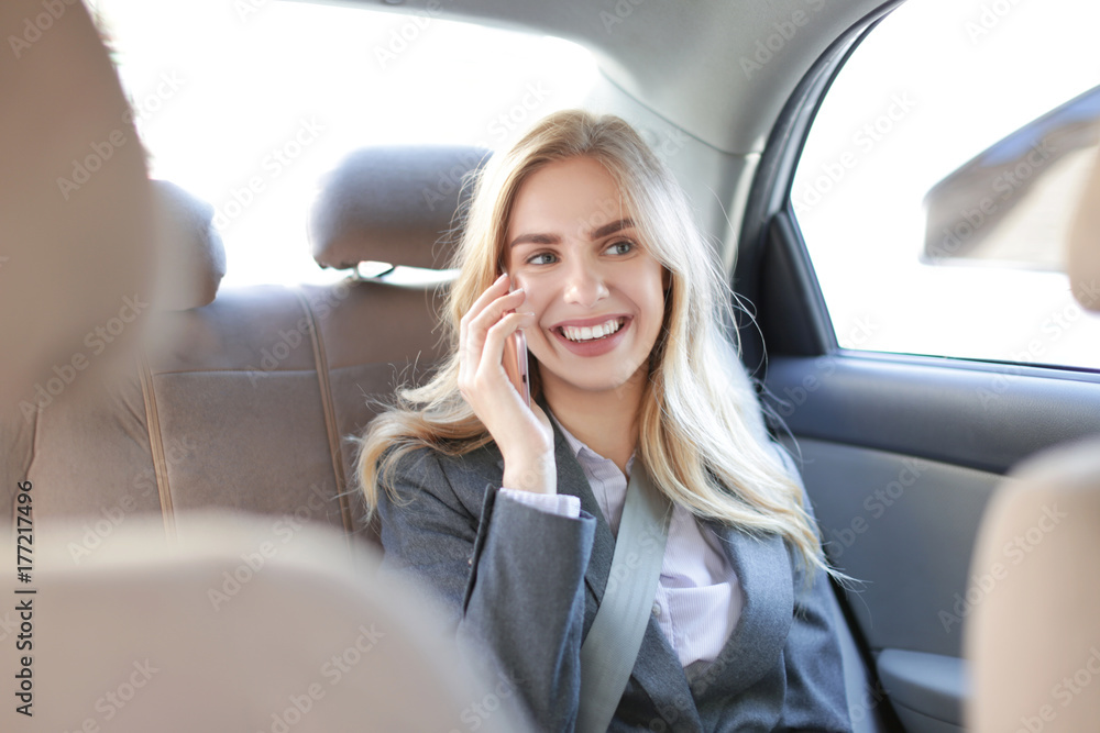 Young businesswoman talking on mobile phone in car Young businesswoman talking on mobile phone in car