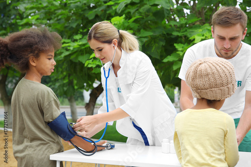 Photos Volunteer doctor measuring blood pressure of poor African child outdoors