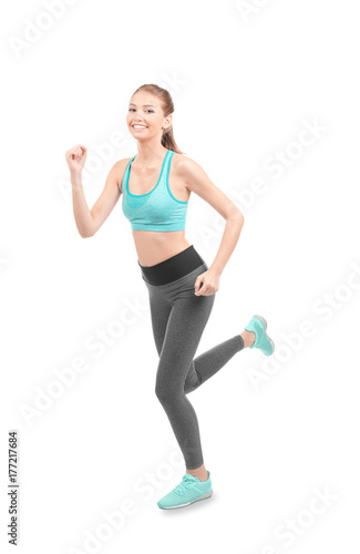 Young sporty woman running on white background