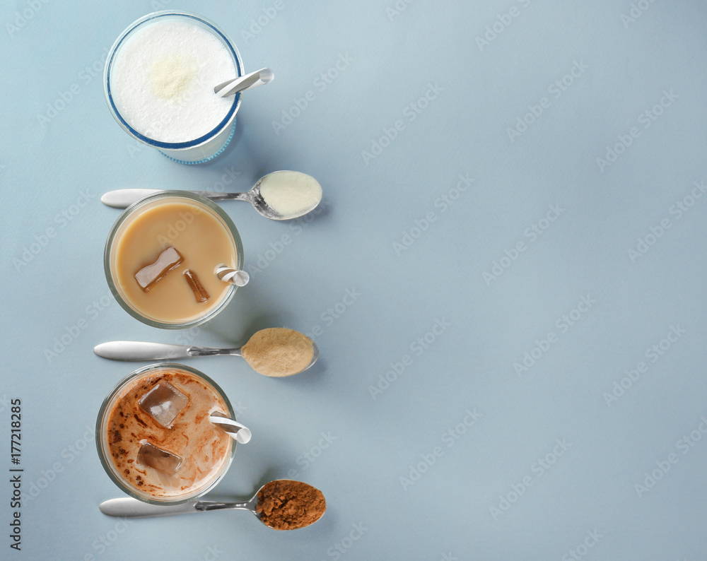 Fototapeta premium Glasses with different protein shakes and powders in spoons on table