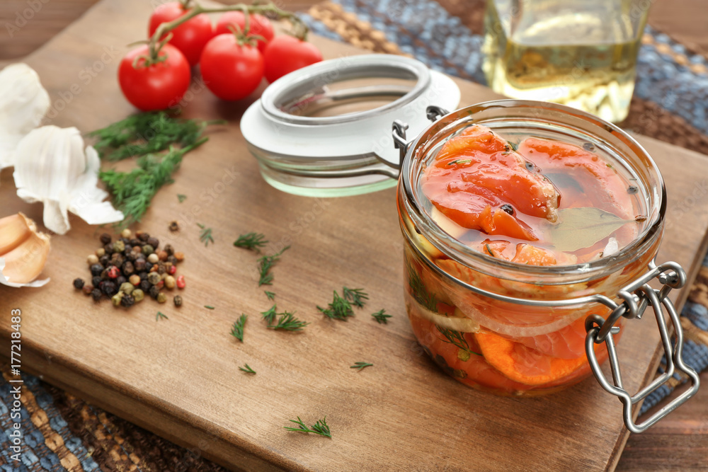 Jar with delicious marinated salmon on table Jar with delicious marinated salmon on table