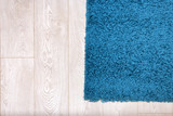 Beautiful blue carpet on wooden floor