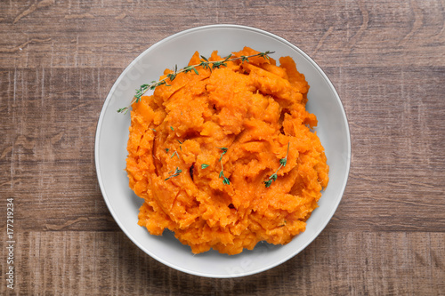 Foto Bowl with mashed sweet potato on wooden background