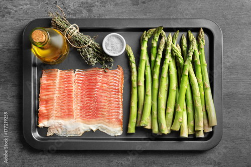 Plate with bacon wrapped asparagus on light background photo