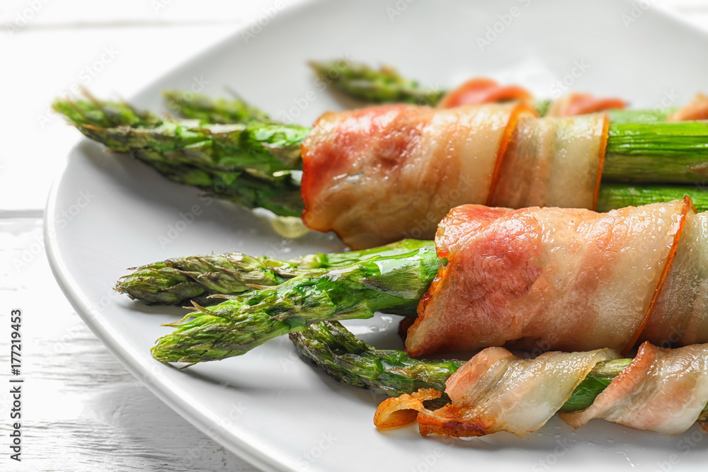 Plate with bacon wrapped asparagus on light background Plate with bacon wrapped asparagus on light background