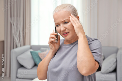 Senior woman speaking on ce...