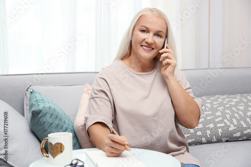 Senior woman speaking on ce...
