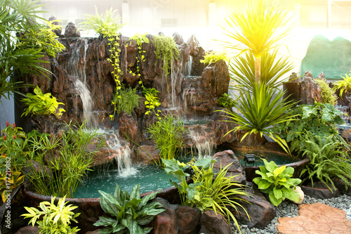 Selective focus of green forest with water fall in the department store. photo