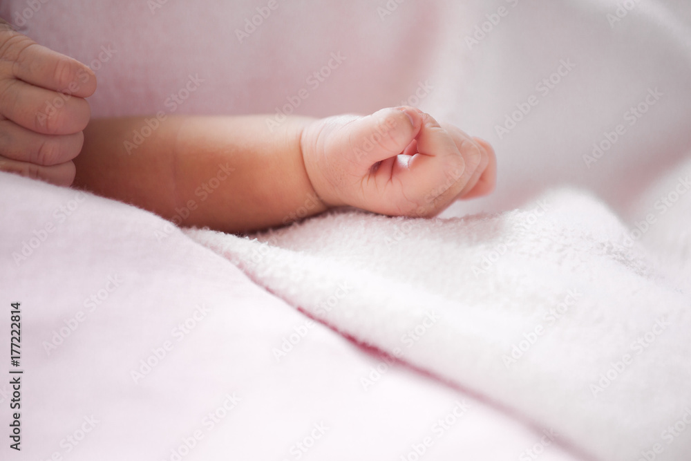Newborn baby hand on pink blanket in soft color tone Newborn baby hand on pink blanket in soft color tone