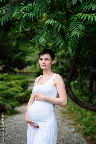 Beautiful pregnant girl in a white dress outdoors. Free Download Beautiful pregnant girl in a white dress outdoors. - GFXLoad