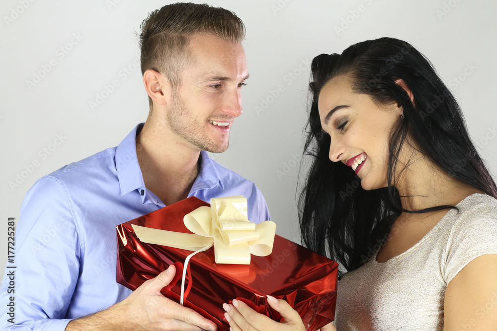 Cheerful happy couple offering a present on a white background Cheerful happy couple offering a present on a white background