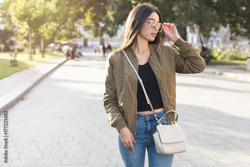Obraz na plátně Fashion close up portrait stylish woman in fall spring casual outfit walking in city
