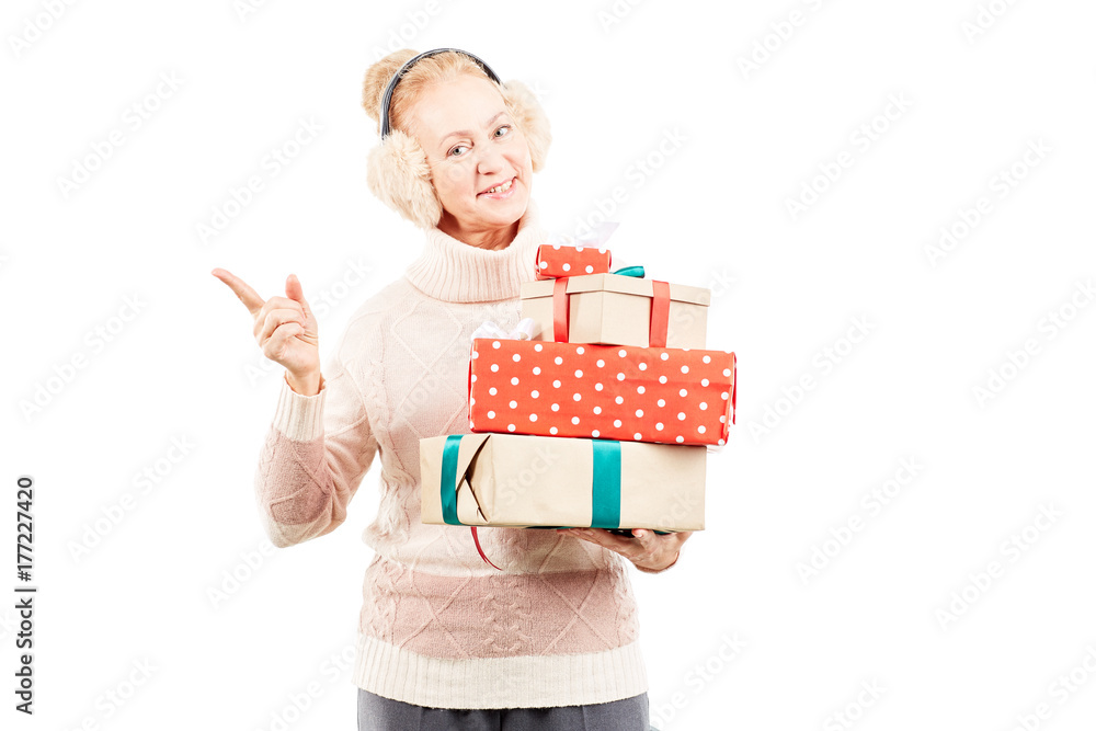 Portrait of senior woman in earmuffs holding heap of Christmas gifts Portrait of senior woman in earmuffs holding heap of Christmas gifts