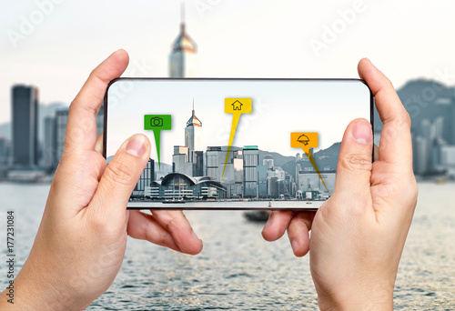 Traveler hold mobile phone and using augmented reality ( AR ) for see travel place information over the cityscape,Digital lifestyle Technology concept photo