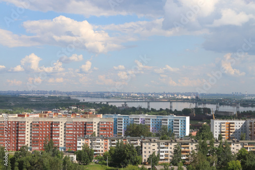 Bridge over river, residential area and panoramic view of city in summer day photo