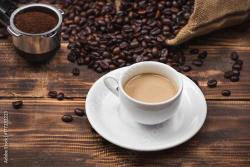 Coffee cup and beans on a rustic background
