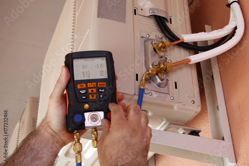 Instalador verificando el compresor de aire acondicionado