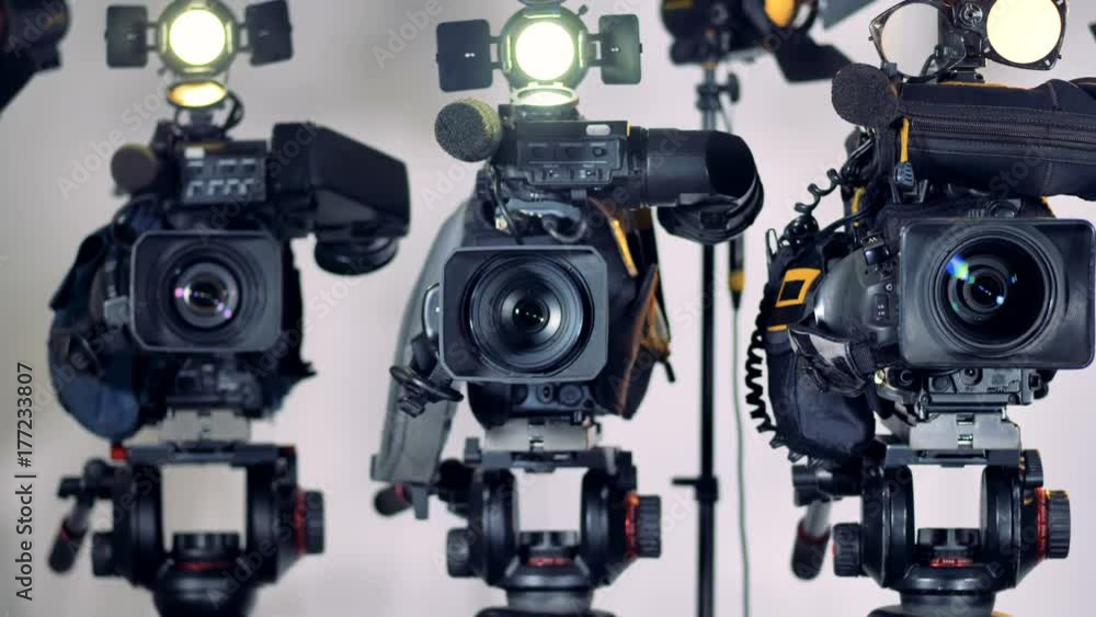 A zooming in on three professional video cameras. A zooming in on three professional video cameras.