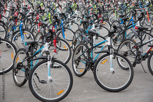 A row of a large number of bicycles with wheels on the town square in summer
