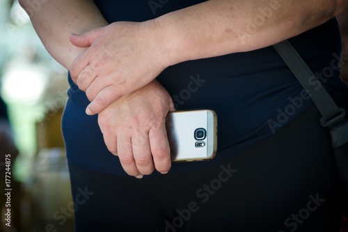 older woman holding smartphone in public outdoor