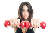 Selective focus of girl exercising with two dumbbells