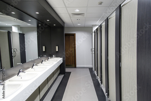 Public bathroom with sinks, mirrors and cubicles
