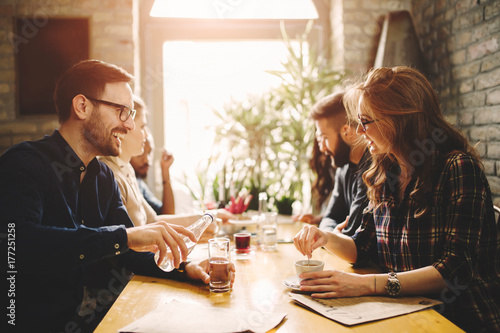 Canvas Print Happy colleagues from work socializing in restaurant