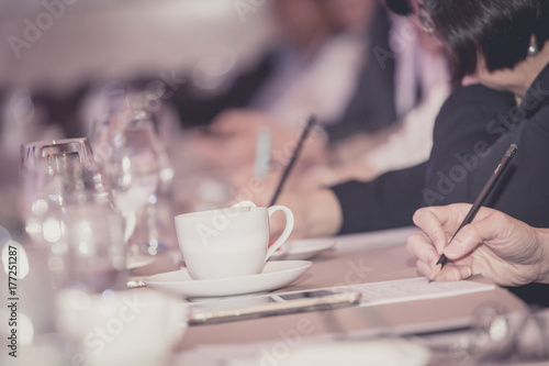 businesspeople hands with pen or pencil , papers and cups of coffee in the seminar room