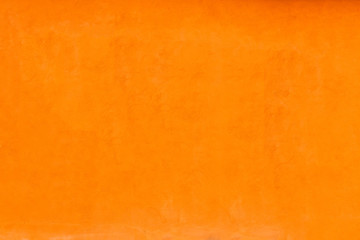 Vivid bright orange color facade wall as an empty rustic background texture space.
