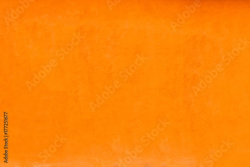 Vivid bright orange color facade wall as an empty rustic background texture space.