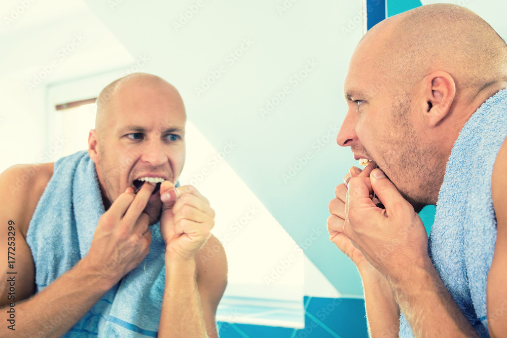 Man looks at the mirror in the bathroom. Man looks at the mirror in the bathroom.