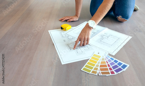 Young woman looking house plans on the floor photo