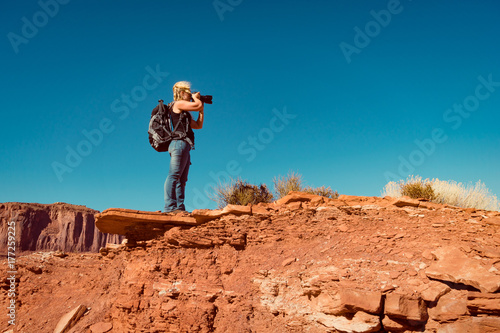 woman taking landscape photos in Arizona standing on a rock. © 2mmedia