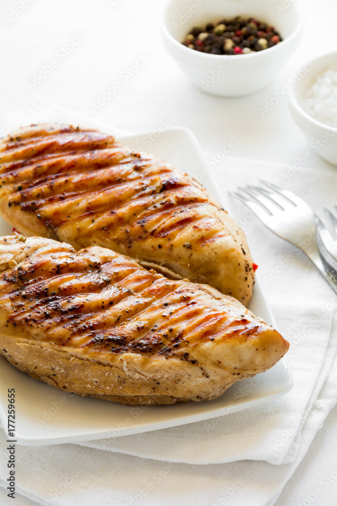 Grilled chicken breast on white table cloth Grilled chicken breast on white table cloth