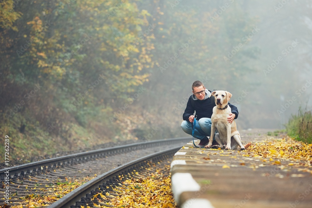 Fototapeta premium Man traveling with his dog by train